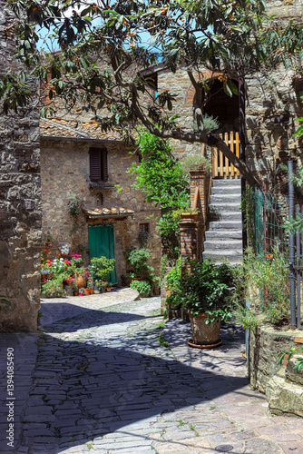 Obraz na płótnie arrow cobblestone streets of Castello di Montefioralle, where medieval houses adorned vibrant flowers create a picturesque atmosphere in Tuscany. Greve in Chianti, Tuscany, Italy. w salonie