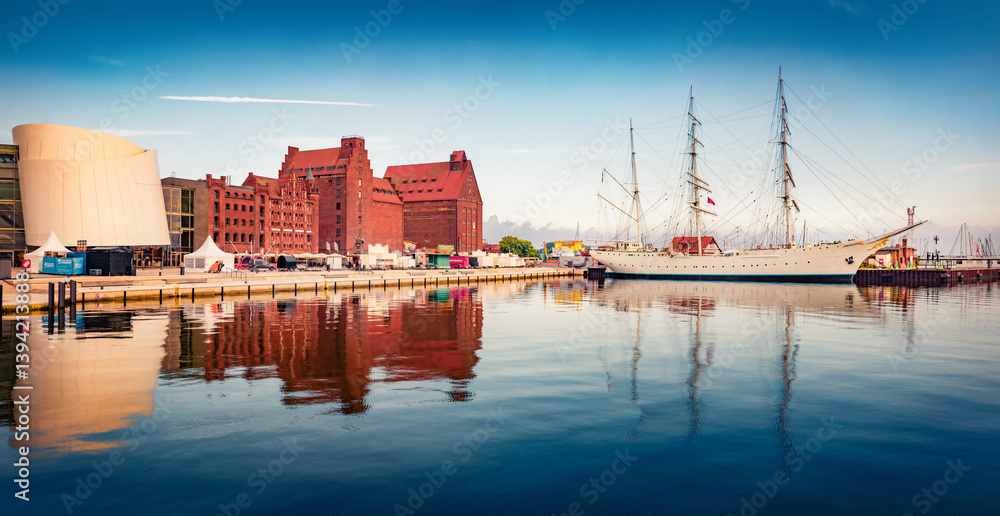 Panoramic summer view of big white sailboat and colorful buildings in Stralsund port, Germany, Europe. Calm morning seascape of Baltic Sea. Traveling concept background.