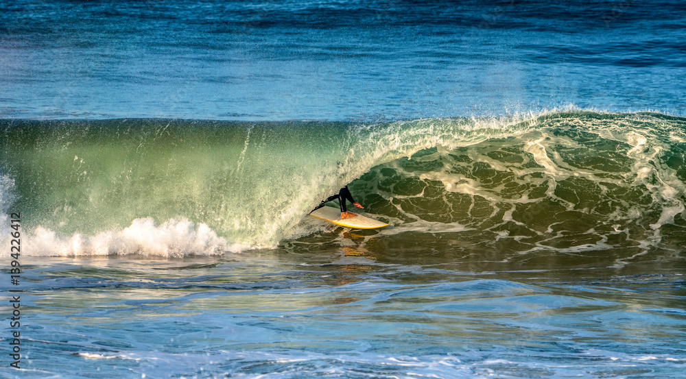 Surfer's feet and board showing through the closing of a large wave