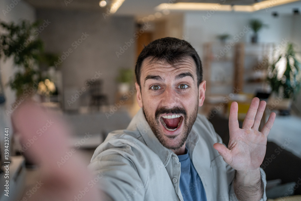 Obraz premium Enthusiastic man making a video call from home