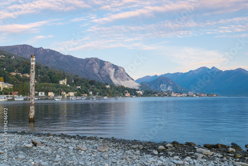 Stresa and lake Maggiore at sunrise, Italy. Panorama from the lakefront of the town of Stresa towards Baveno, in the distance. Large lake in northern Italy