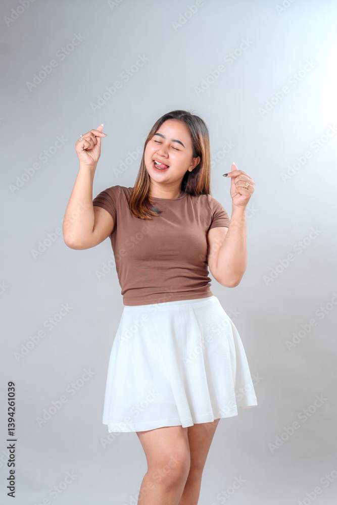 Joyful young woman smiling brightly while making finger heart gesture with both hands. Expressive facial emotion suitable for advertising, marketing, or promotional content. Joyful young woman smiling brightly while making finger heart gesture with both hands. Expressive facial emotion suitable for advertising, marketing, or promotional content.