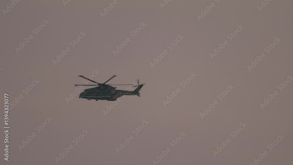 Military helicopter flying in cloudy sky Military helicopter flying in cloudy sky