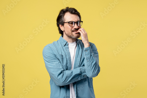 Valokuvatapetti Pensive entrepreneur biting nails and feeling anxious on yellow background