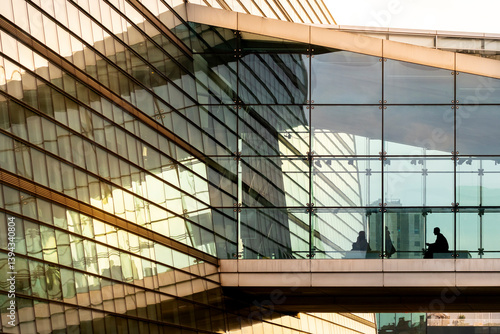 Golden glass facade with evening reflections and warm light geometry, modern structure with elegant symmetry and soft glow