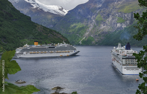 Modern mega cruiseship cruise ship liner Favolosa in Geirangerfjord with panoramic views of Geiranger and the breathtaking mountain scenery and fjord landscape nature during Norway cruising