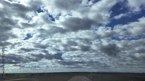 A pilot’s viewof a real time take off as seen from inside the ccokpit of a jet airplane taking off from an isolated runway, under a deep blue sky with some cottony clouds. 4K