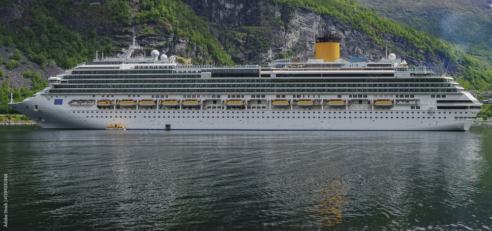 Modern mega cruiseship cruise ship liner Favolosa in Geirangerfjord with panoramic views of Geiranger and the breathtaking mountain scenery and fjord landscape nature during Norway cruising