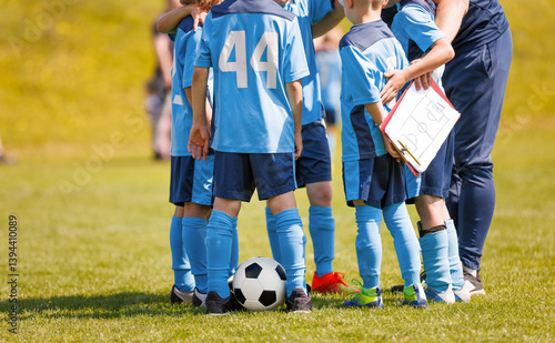 Картината върху платно Football players in a circle huddling with a coach during time break