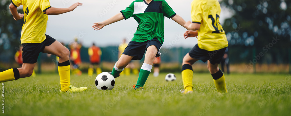 Youth Soccer Game. Group of Boys Play Football Game Together. School Kids in Two Soccer Teams Kicking Ball During Tournament Match. Youth Junior Athletes in Yellow and Green Soccer Shirts Youth Soccer Game. Group of Boys Play Football Game Together. School Kids in Two Soccer Teams Kicking Ball During Tournament Match. Youth Junior Athletes in Yellow and Green Soccer Shirts