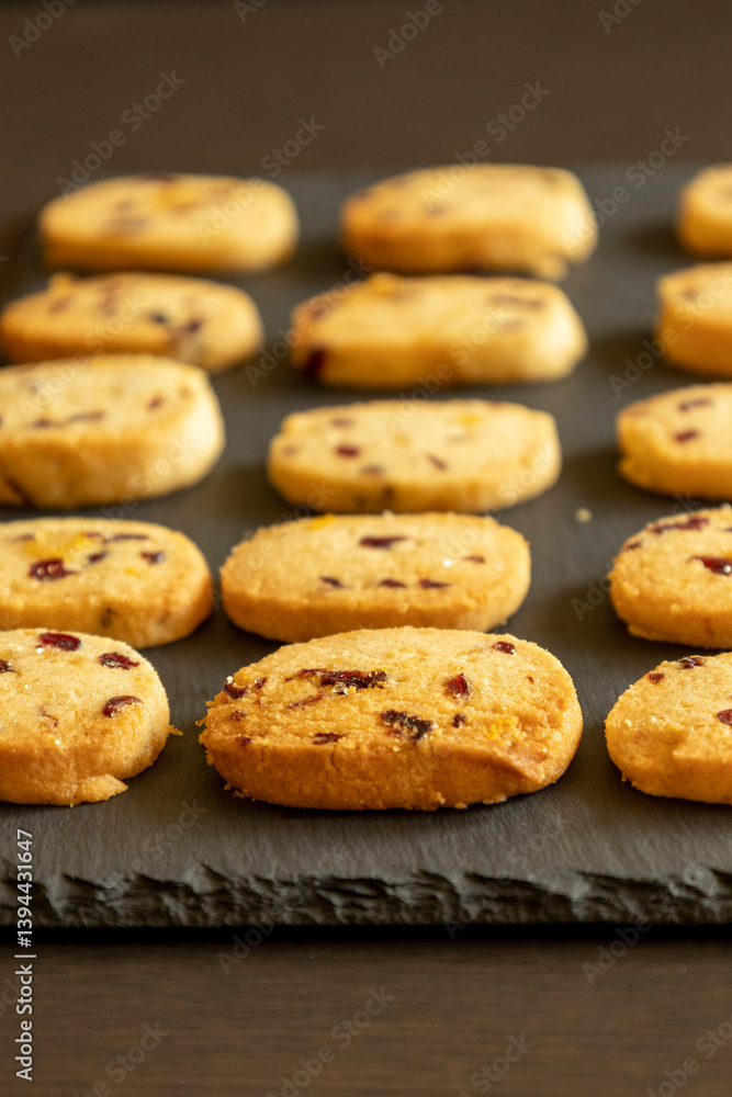 freshly baked orange and cranberry cookies arranged on a dark background freshly baked orange and cranberry cookies arranged on a dark background