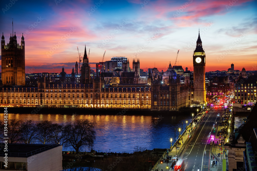 Elevated view of the illuminated Westminster Palace and Big Ben clock tower in London, England, during a colorful evening