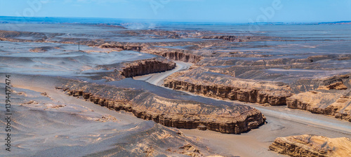 Obraz na płótnie A winding road leads through the unique Yardang landform in Xinjiang. Famous Dahaidao no man's land natural scenery in China. w salonie