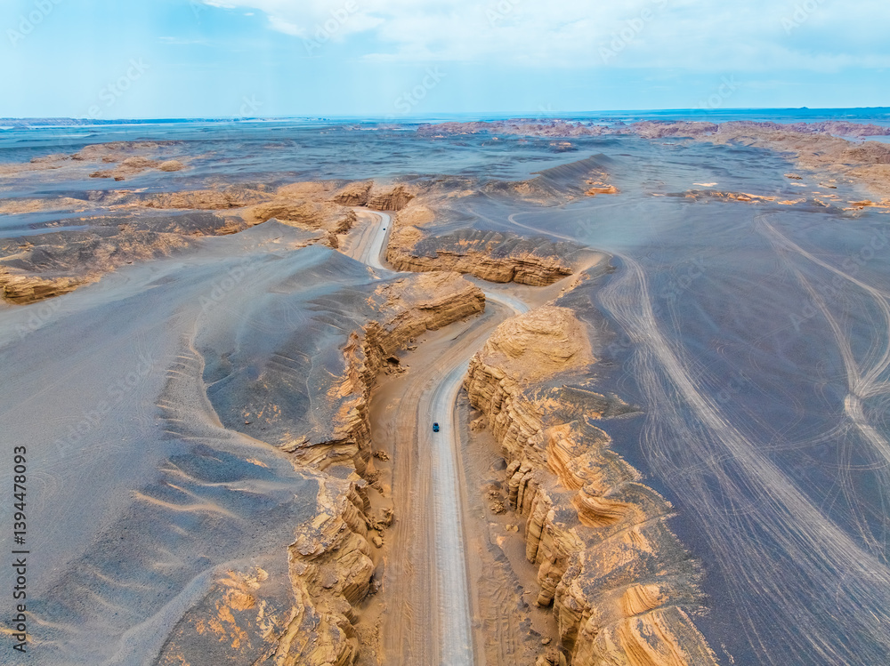 Aerial view of cars driving through yardang landform in Xinjiang. Famous Dahaidao no man's land natural scenery in China.