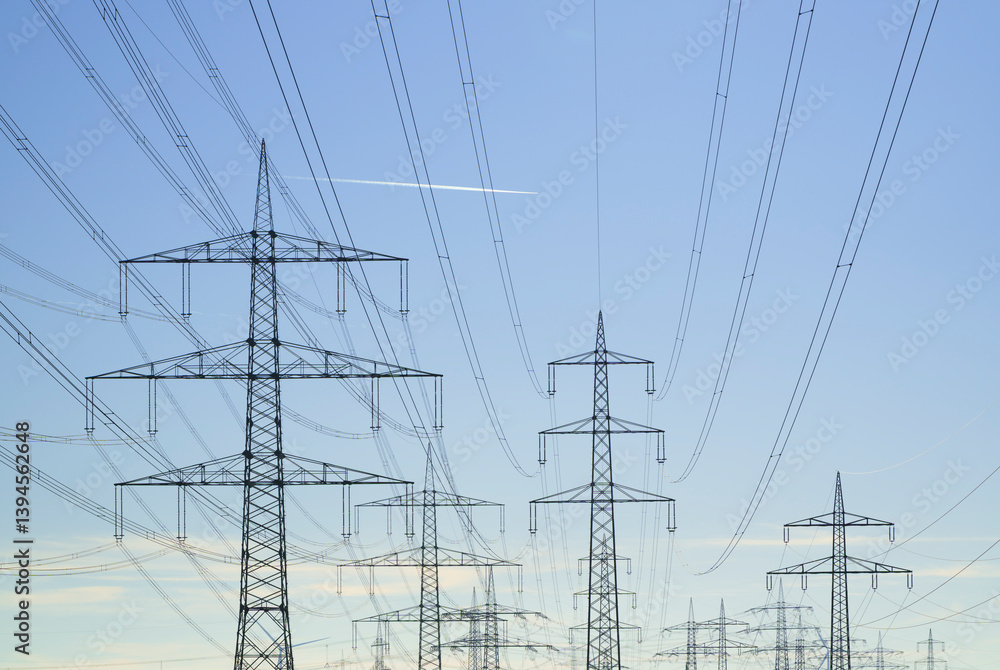 Power lines and transmission towers in Garzweiler under a clear blue sky Power lines and transmission towers in Garzweiler under a clear blue sky