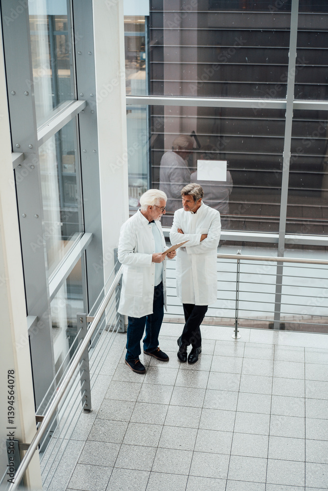Doctors discussing diagnosis in a hospital corridor Doctors discussing diagnosis in a hospital corridor