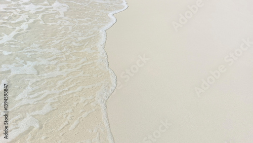 Crystal clear water gently washing the shore of a tropical beach with white sand, creating a relaxing summer atmosphere