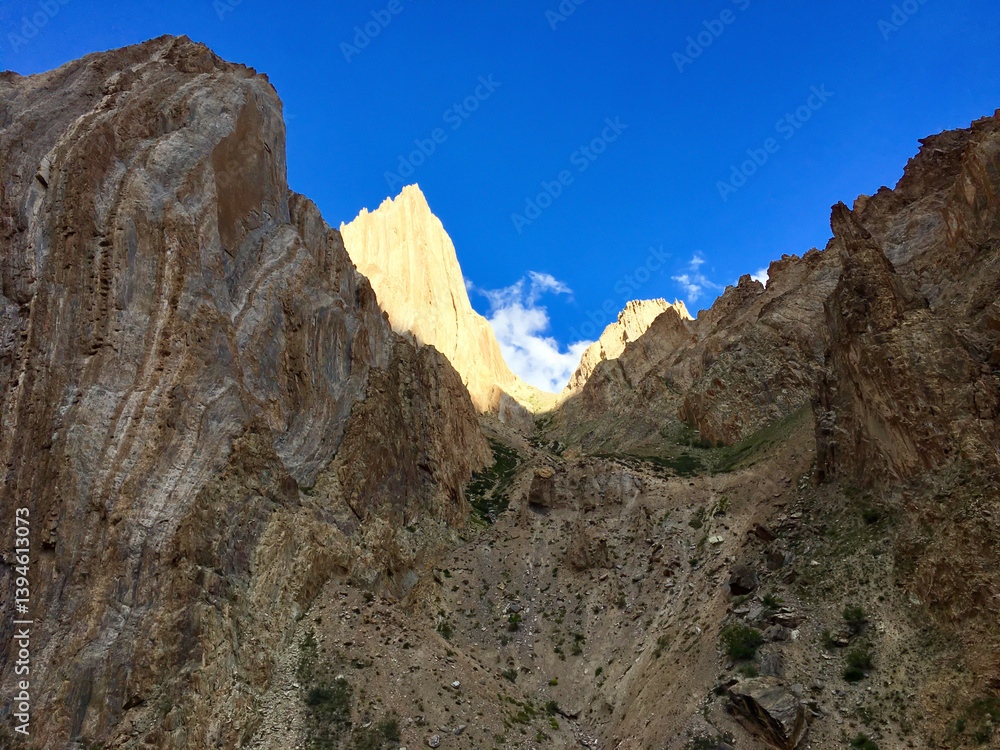 Dramatic light illuminates rugged mountain cliffs in Leh Ladakh against a vibrant blue sky, highlighting the region's natural beauty Dramatic light illuminates rugged mountain cliffs in Leh Ladakh against a vibrant blue sky, highlighting the region's natural beauty