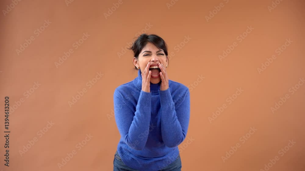 Joyful woman laughing and shouting in blue sweater expressing strong emotions Joyful woman laughing and shouting in blue sweater expressing strong emotions