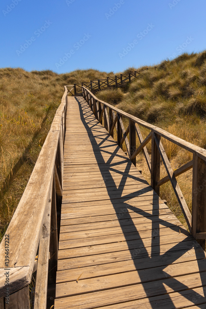 Fototapeta premium Wooden walkway on dunes at Cala Mesquida, Mallorca, Spain.