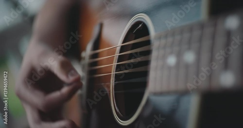Close up of hands strumming and playing the acoustic guitar 