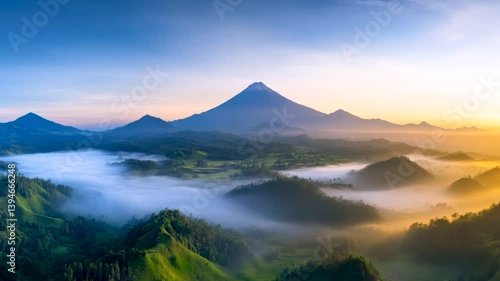 Scenic aerial shot of a misty mountain valley at sunrise, fog rolling over the peaks