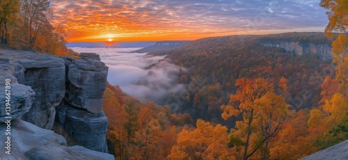 Stunning autumn sunrise over misty valley with vibrant fall foliage and rocky cliffs