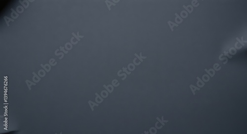 Paper surface background.  a blurry image of a gray surface with some indistinct shapes in the corners of frame
