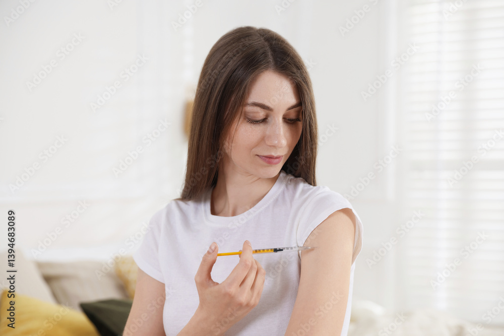 Woman making insulin injection into her arm indoors. Diabetes Woman making insulin injection into her arm indoors. Diabetes