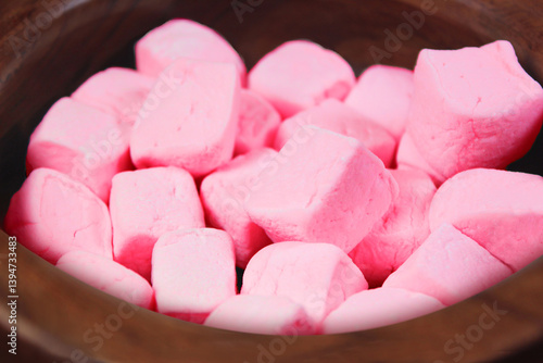 Pink marshmallows close up bokeh view in a wooden bowl