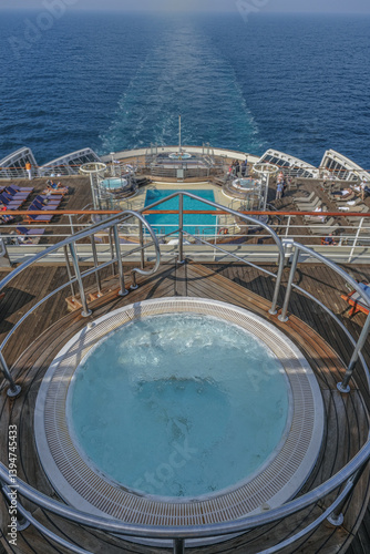 Obraz na płótnie Views onto outdoor teak balcony terrace veranda promenade sun pool deck of ocean liner cruiseship cruise ship with chairs loungers at sea during Transatlantic Crossing to New York on beautiful sun day w salonie