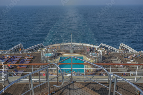 Obraz na płótnie Views onto outdoor teak balcony terrace veranda promenade sun pool deck of ocean liner cruiseship cruise ship with chairs loungers at sea during Transatlantic Crossing to New York on beautiful sun day w salonie
