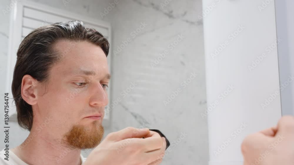Man Looking in Mirror Applying Black Mouth Tape to Lips Before Sleep with Both Hands in Close-Up View for Better Nasal Breathing Concept Man Looking in Mirror Applying Black Mouth Tape to Lips Before Sleep with Both Hands in Close-Up View for Better Nasal Breathing Concept