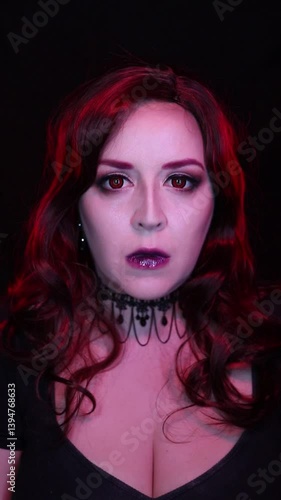 Wallpaper Mural Mysterious woman with gothic vampire makeup and red hair, wearing dark lipstick and a black lace choker. Dramatic lighting highlights her intense eyes and ethereal beauty.  Torontodigital.ca