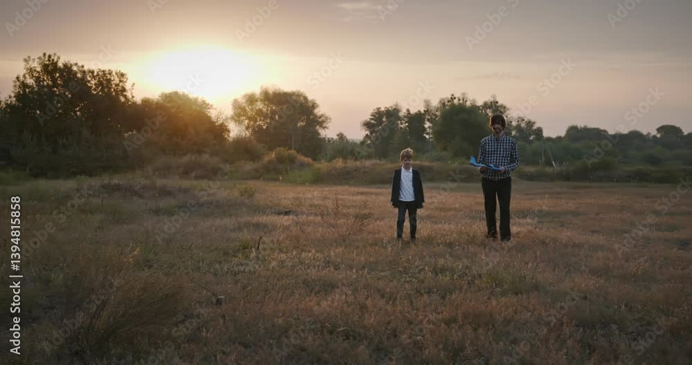Man and Boy Play with Toy Airplane on Field. Dad and Child Spend Time Together on Nature 4K 10-bit Man and Boy Play with Toy Airplane on Field. Dad and Child Spend Time Together on Nature 4K 10-bit