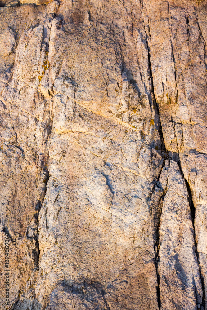 natural sea rock texture with crack. outdoor background of sandstone surface in morning light. closeup of rough stone on coast terrain. dry environment
