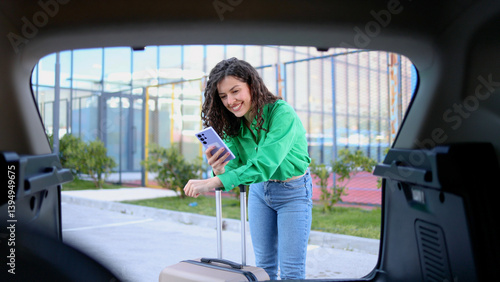 Wallpaper Mural Traveler loading luggage, checking smartphone near rental vehicle Torontodigital.ca