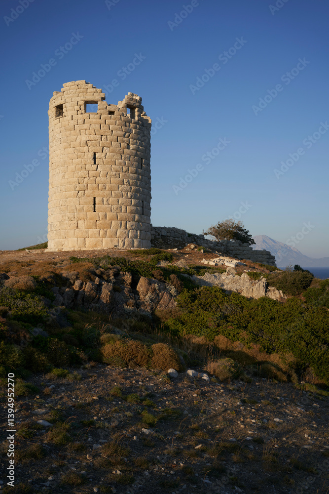 Stone tower on a rocky hill with clear blue sky and distant mountain view. Stone tower on a rocky hill with clear blue sky and distant mountain view.