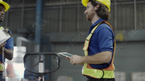 Warehouse workers working in the logistics industry, wearing hard hats, checking stock in a warehouse.