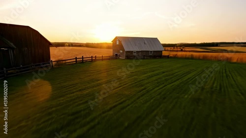A serene sunset over a farm with barns and lush green fields.