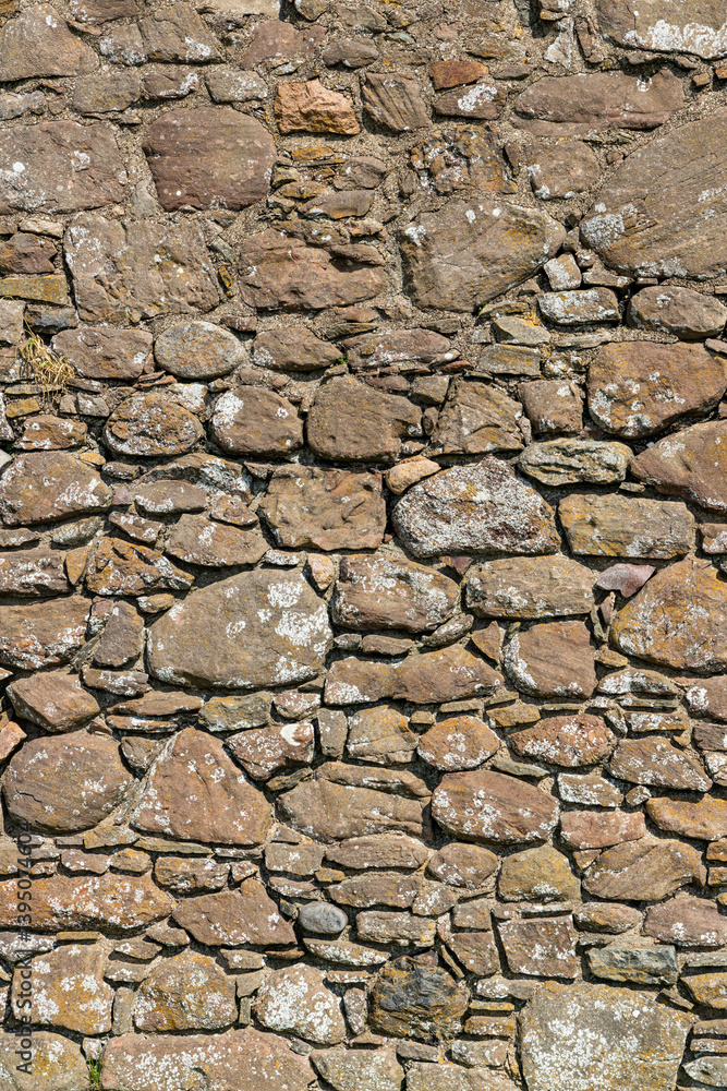 An ancient medieval brick wall tells stories of the past. Its worn textures and weathered details evoke legends and mysteries held within the stones over centuries An ancient medieval brick wall tells stories of the past. Its worn textures and weathered details evoke legends and mysteries held within the stones over centuries