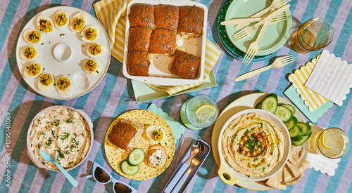 picnic spread with eggs and hummus on striped blanket