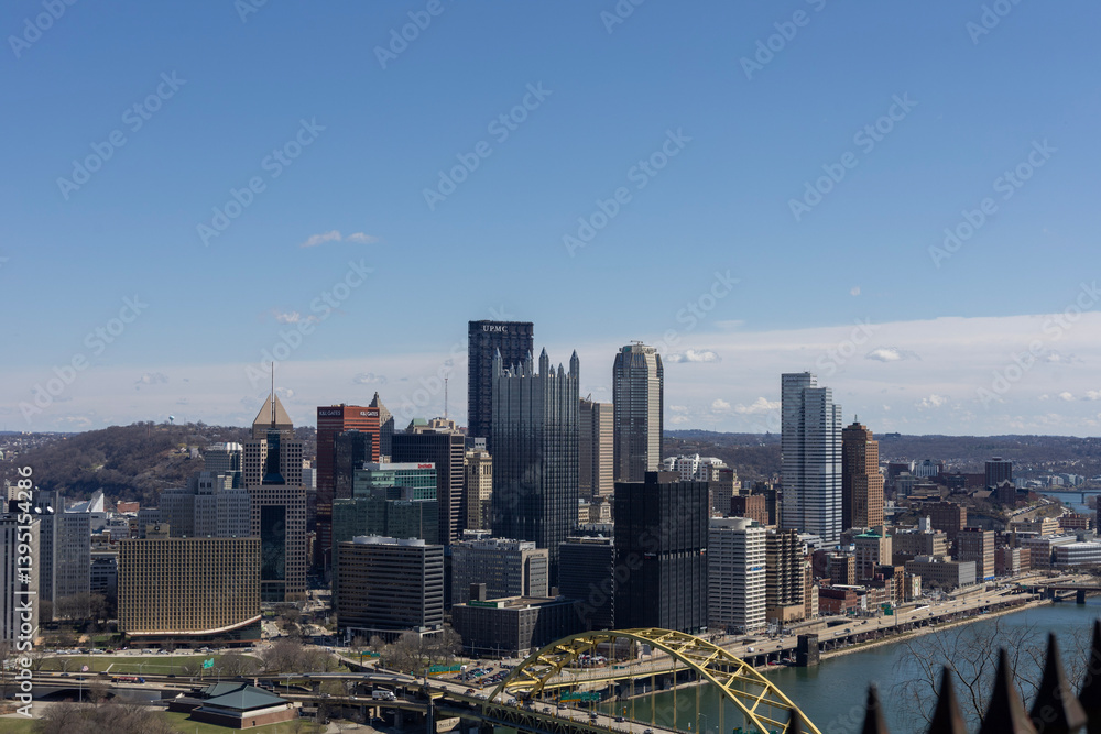 Obraz premium Pittsburgh, Pennsylvania, USA – March 25, 2024: A clear view of downtown Pittsburgh’s skyline from Mount Washington, featuring the U.S. Steel Tower and Fort Duquesne Bridge over the Allegheny River.