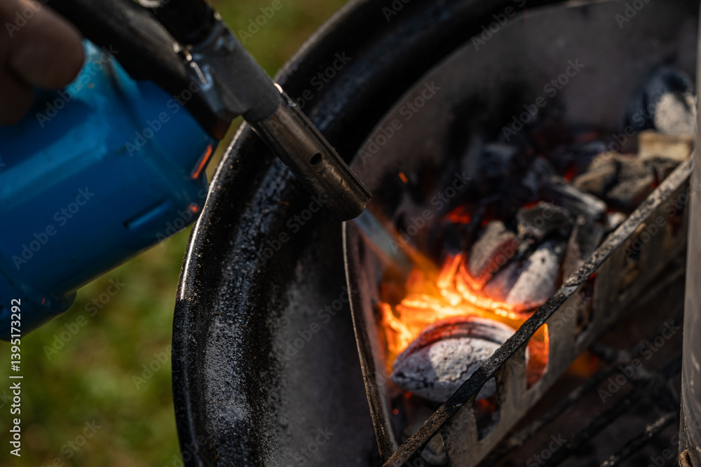 accendendo delle carbonelle in una griglia con una fiamma ossidrica