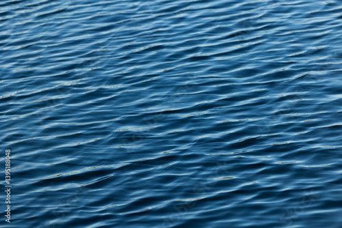 Obraz na płótnie superficie d'acqua di mare o fiume tranquilla e di colore blu, con sfumature di azzurro, increspata con piccole onde w salonie