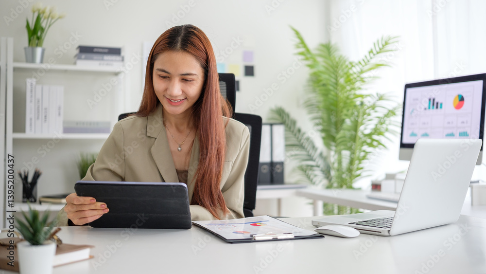Smiling young businesswoman analyzing paperwork while working on laptop in a bright, modern office. Smiling young businesswoman analyzing paperwork while working on laptop in a bright, modern office.
