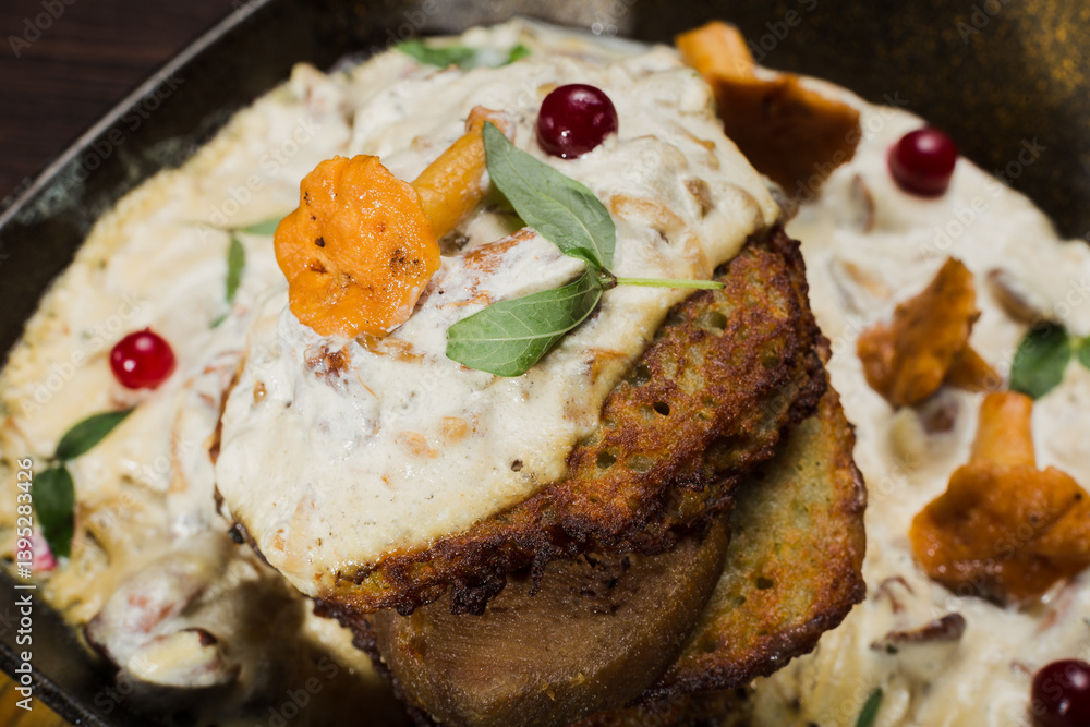 Draniki with chanterelle mushrooms, cream sauce and meat
