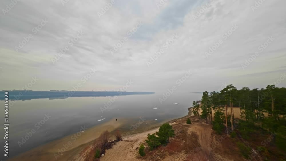 Large and wide river near forest and city. Top view. Panoramic view of river landscape. Spring. Camera rotation over river and forest. City landscape in background. FPV drone flight. Large and wide river near forest and city. Top view. Panoramic view of river landscape. Spring. Camera rotation over river and forest. City landscape in background. FPV drone flight.