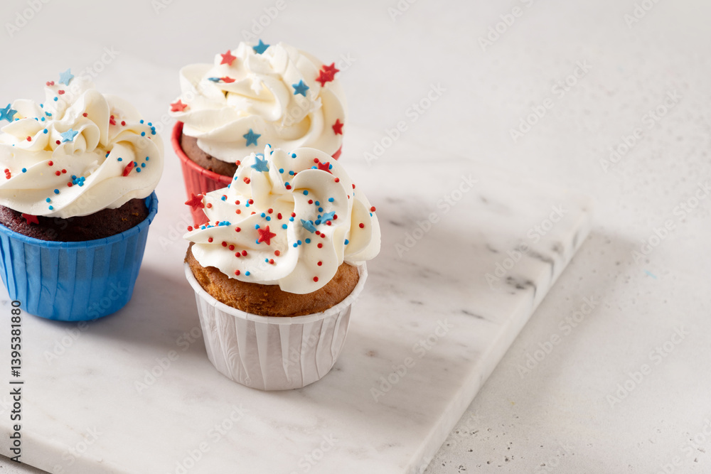 American three sweet cupcakes and USA flag on white table. Dessert for Patriotic Independence Day 4th of July. Close up.