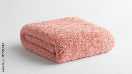 Close-up of a folded, soft, pink bath towel on a white background.